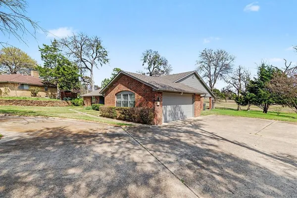 a view of a house with a yard and large tree