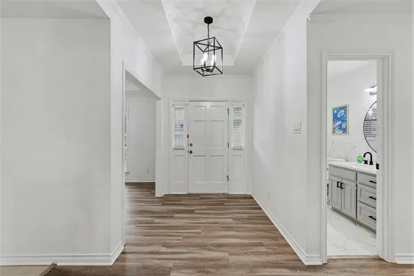 a view of a hallway with wooden floor and staircase