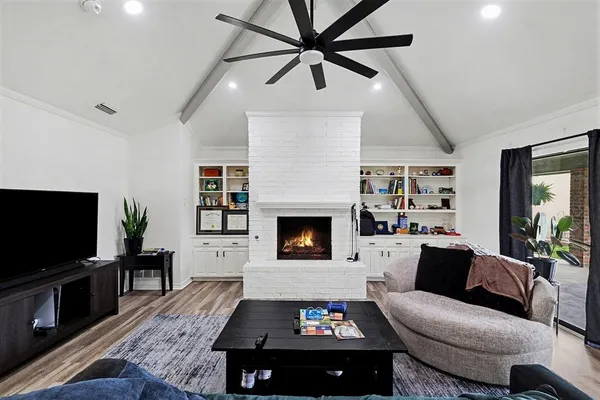 a living room with furniture a flat screen tv and a fireplace