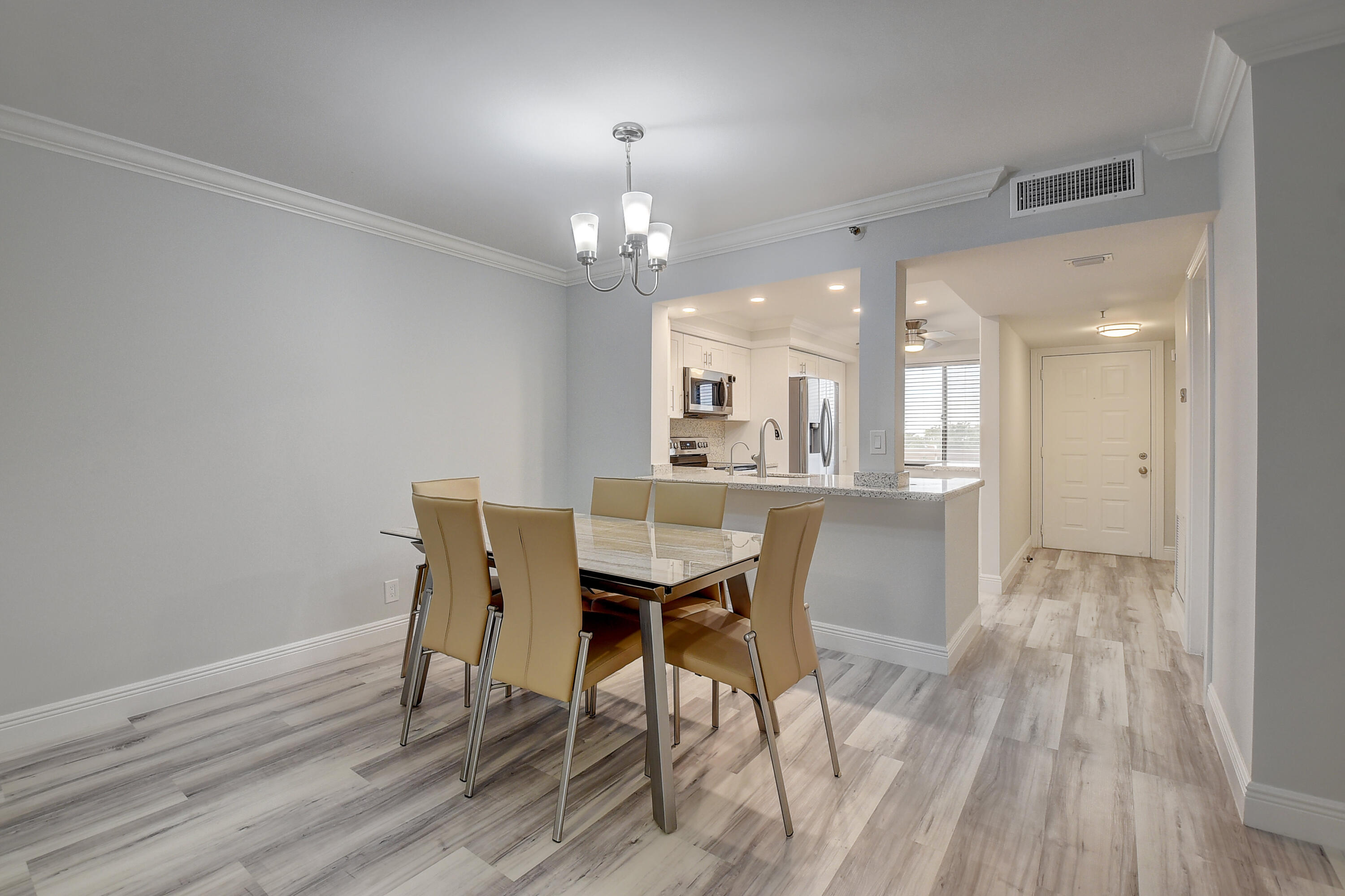7076 Huntington Lane, Unit 507 Delray Beach, FL 33446 - Photo 11 of 48 a view of a dining room with furniture and wooden floor