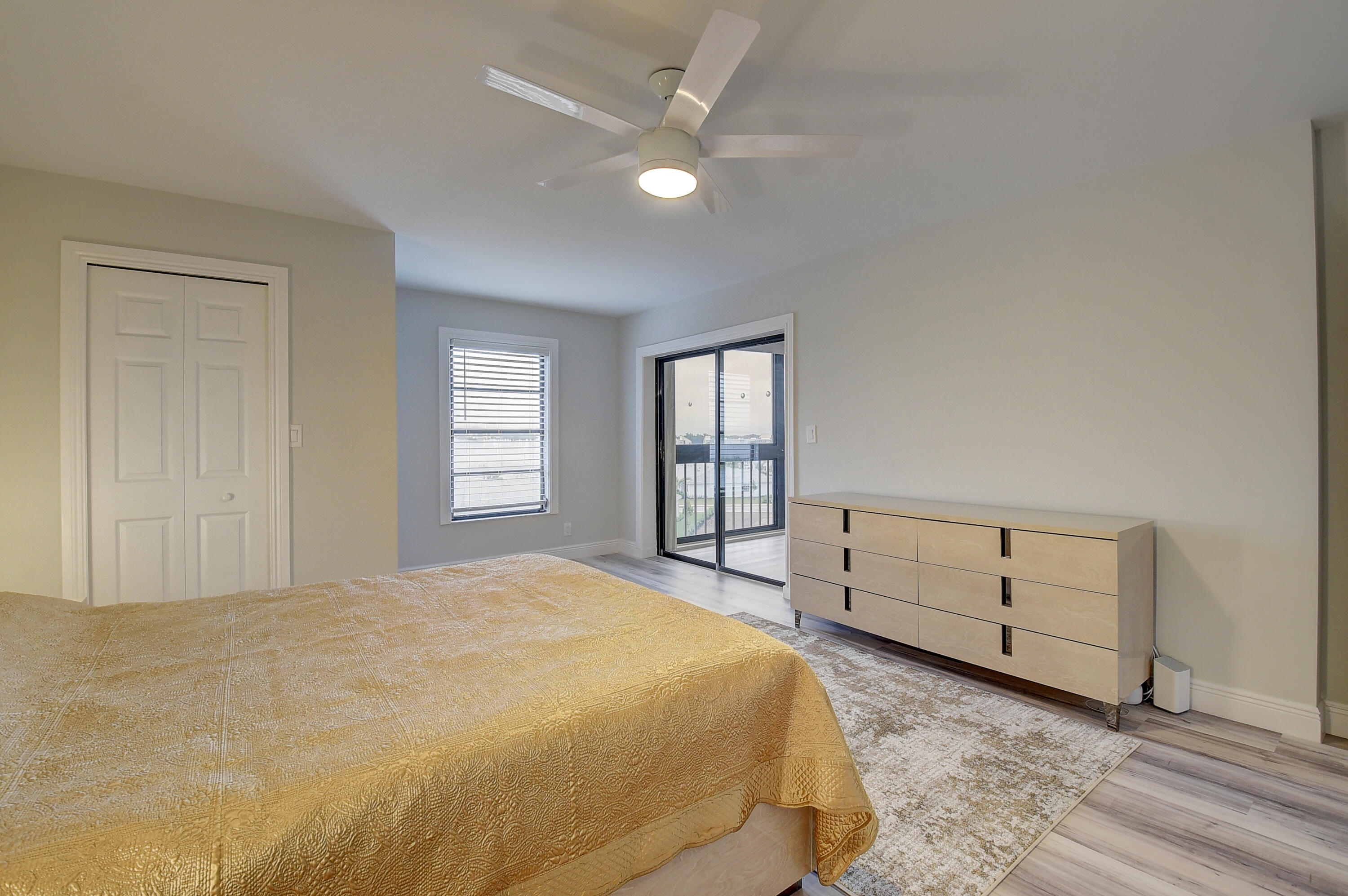 7076 Huntington Lane, Unit 507 Delray Beach, FL 33446 - Photo 18 of 48 a spacious bedroom with a bed and a ceiling fan