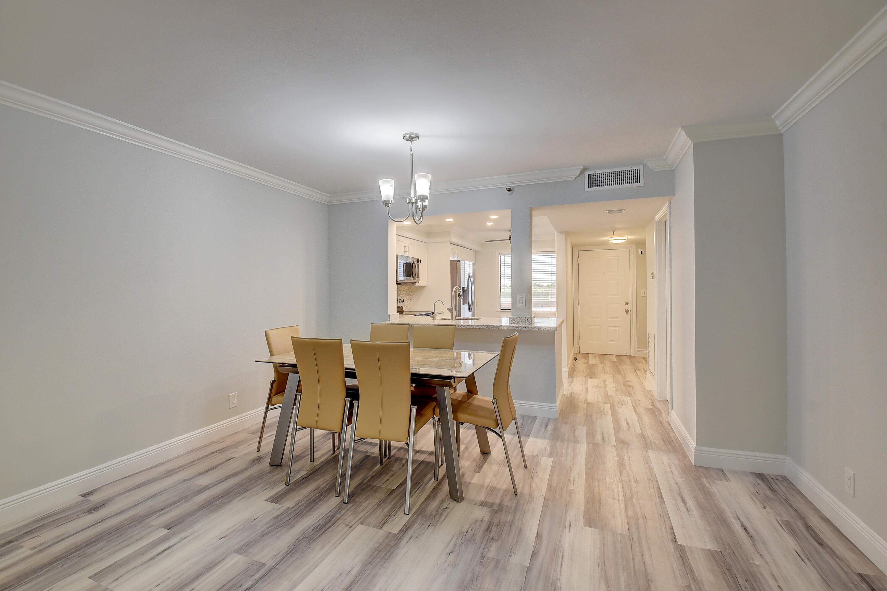 7076 Huntington Lane, Unit 507 Delray Beach, FL 33446 - Photo 5 of 48 a view of a dining room with furniture and wooden floor