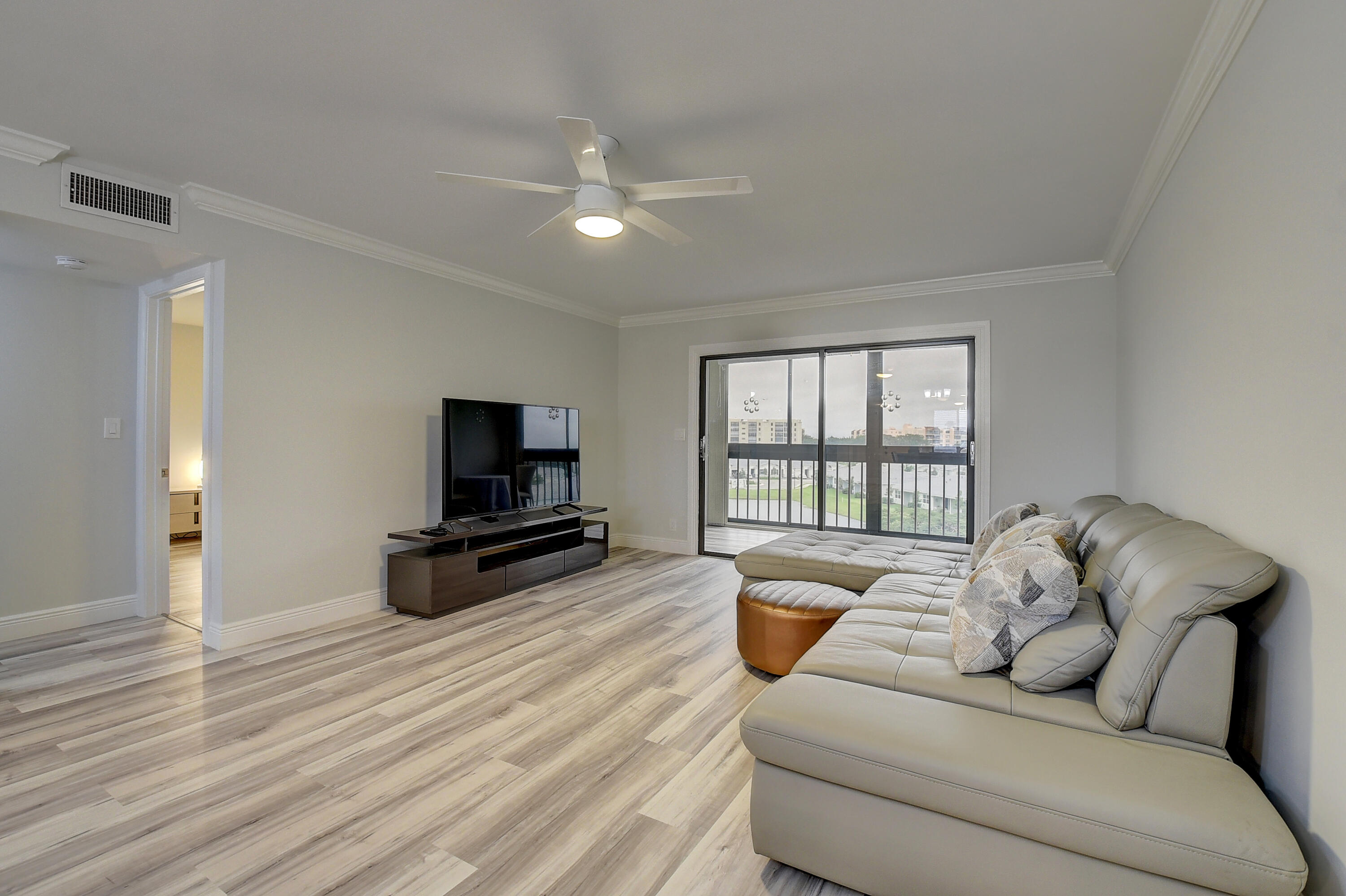 7076 Huntington Lane, Unit 507 Delray Beach, FL 33446 - Photo 9 of 48 a living room with furniture and a flat screen tv