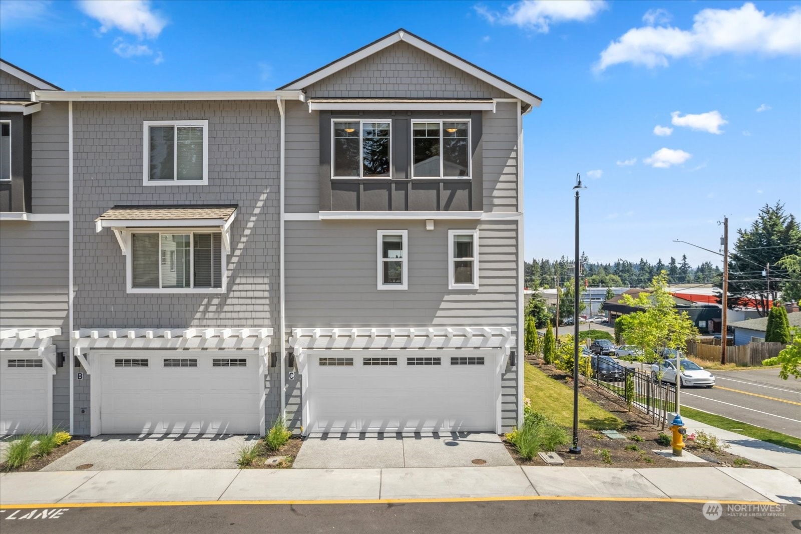 22929 80th Place West, Unit C Edmonds, WA 98026 - Photo 25 of 36 a front view of a house with a yard and garage