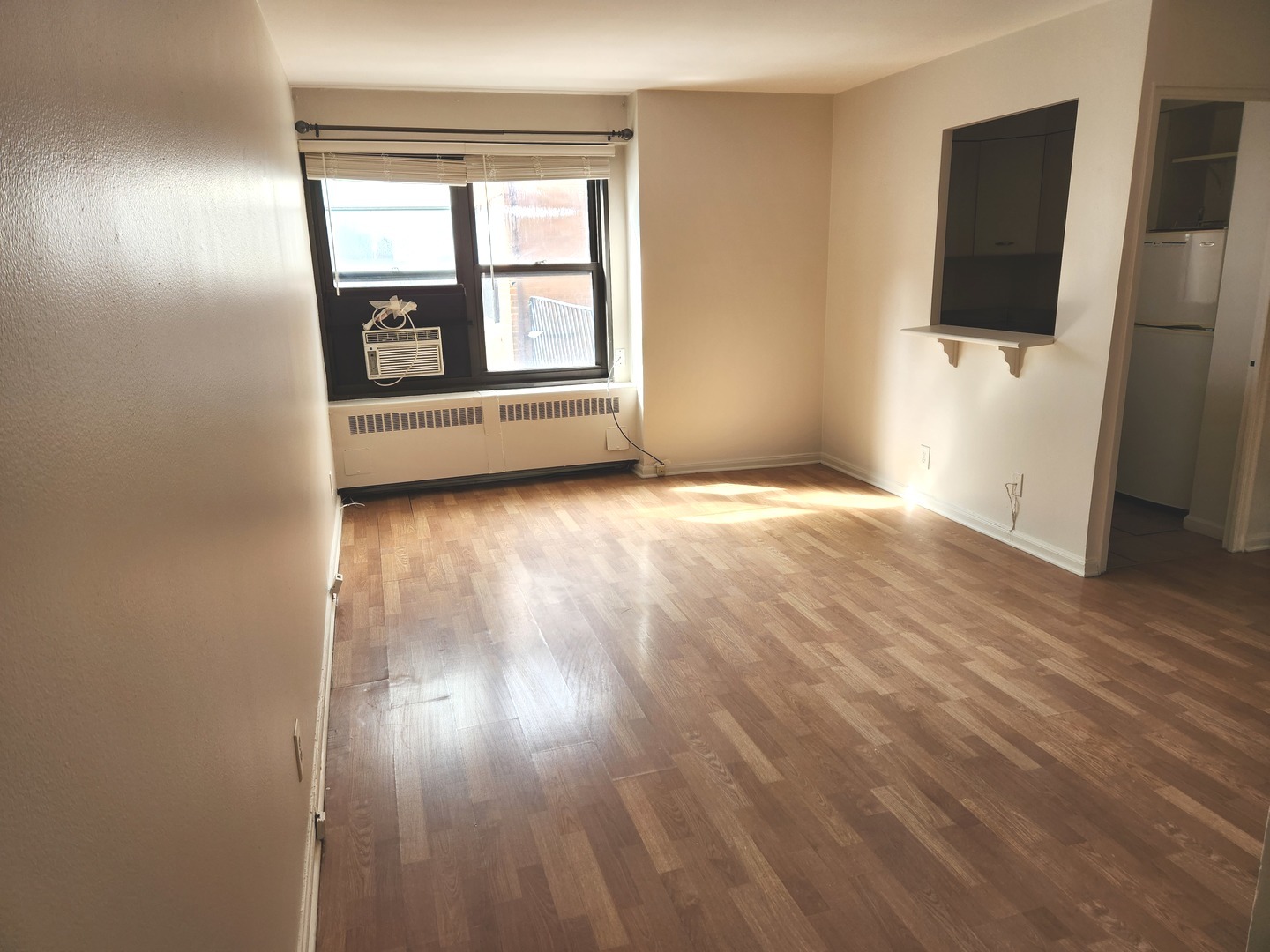 6118 North Sheridan Road, Unit 1206 Chicago, IL 60660 - Photo 2 of 9 an empty room with wooden floor and windows