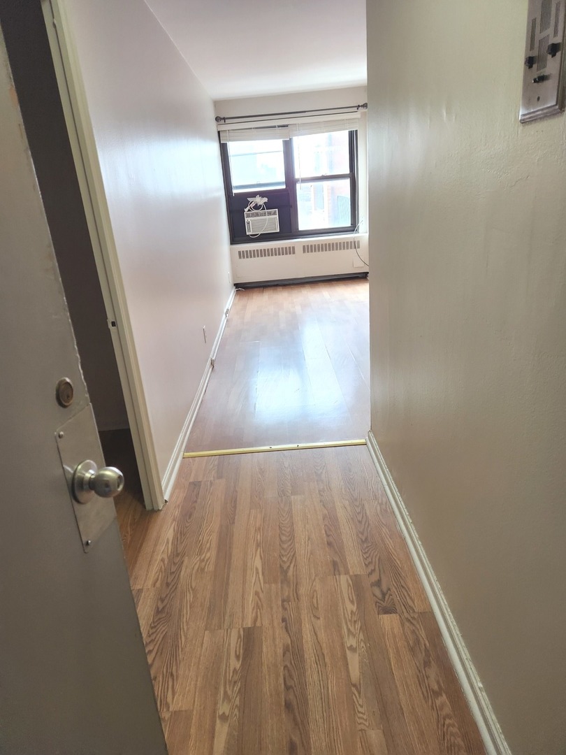 6118 North Sheridan Road, Unit 1206 Chicago, IL 60660 - Photo 6 of 9 wooden floor in an empty room with a window