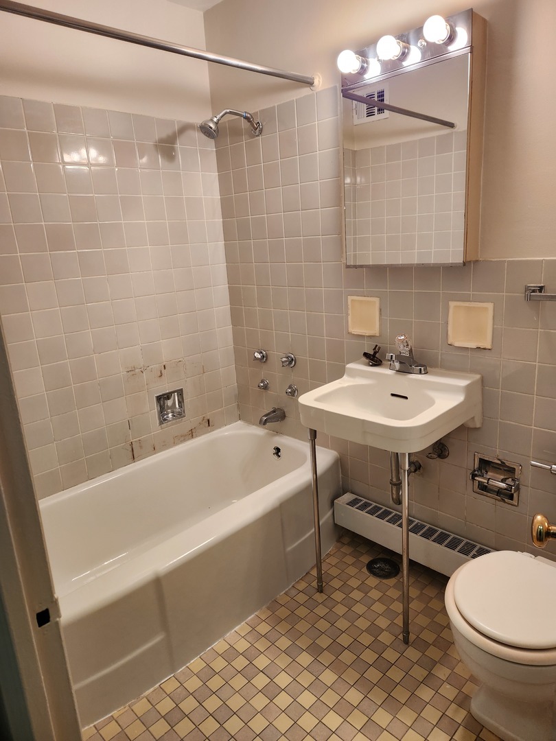 6118 North Sheridan Road, Unit 1206 Chicago, IL 60660 - Photo 7 of 9 a bathroom with a sink a toilet and bathtub
