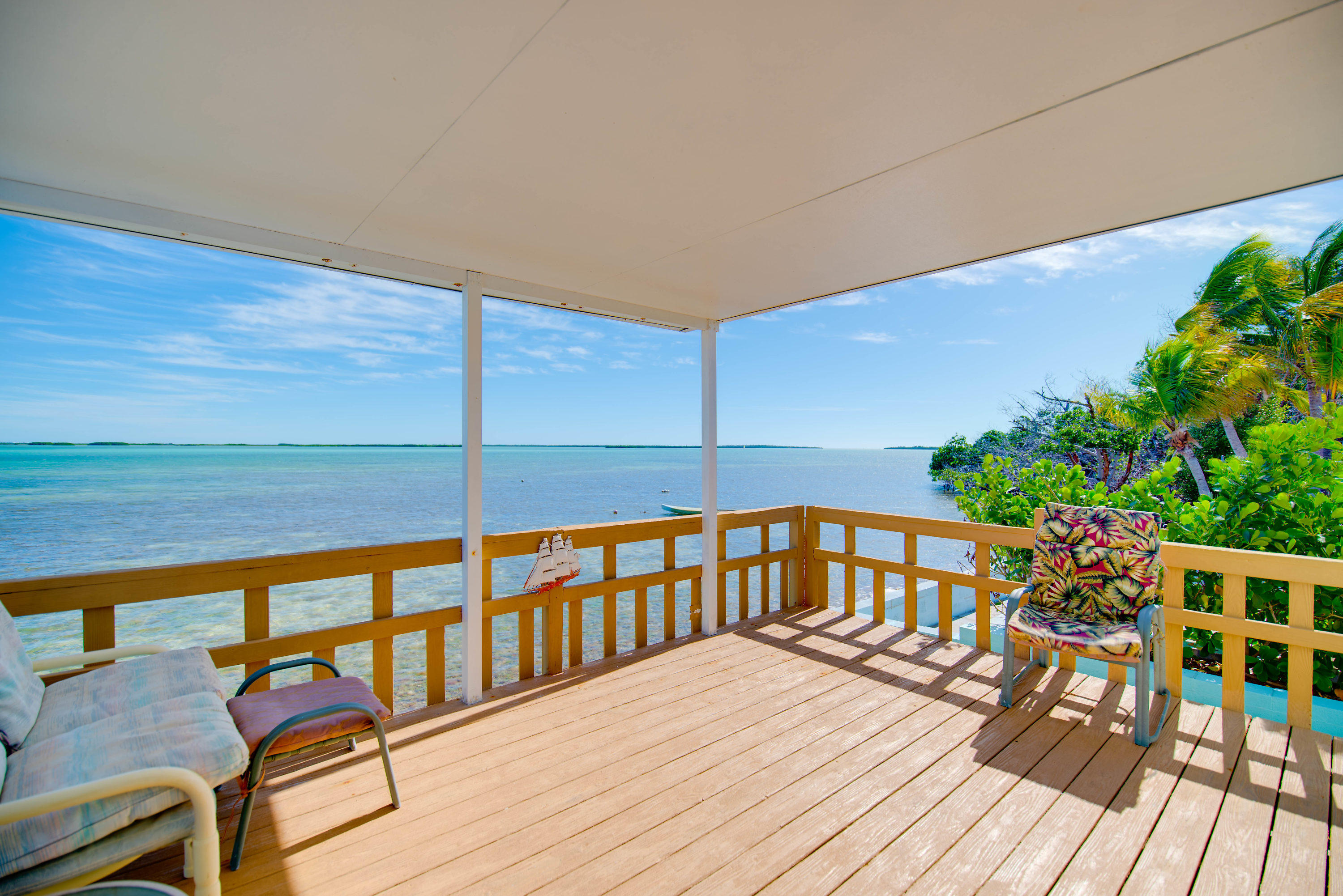 55 Boca Chica Road, Unit 430 Key West, FL 33040 - Photo 3 of 34 a view of a balcony with wooden floor and outdoor seating