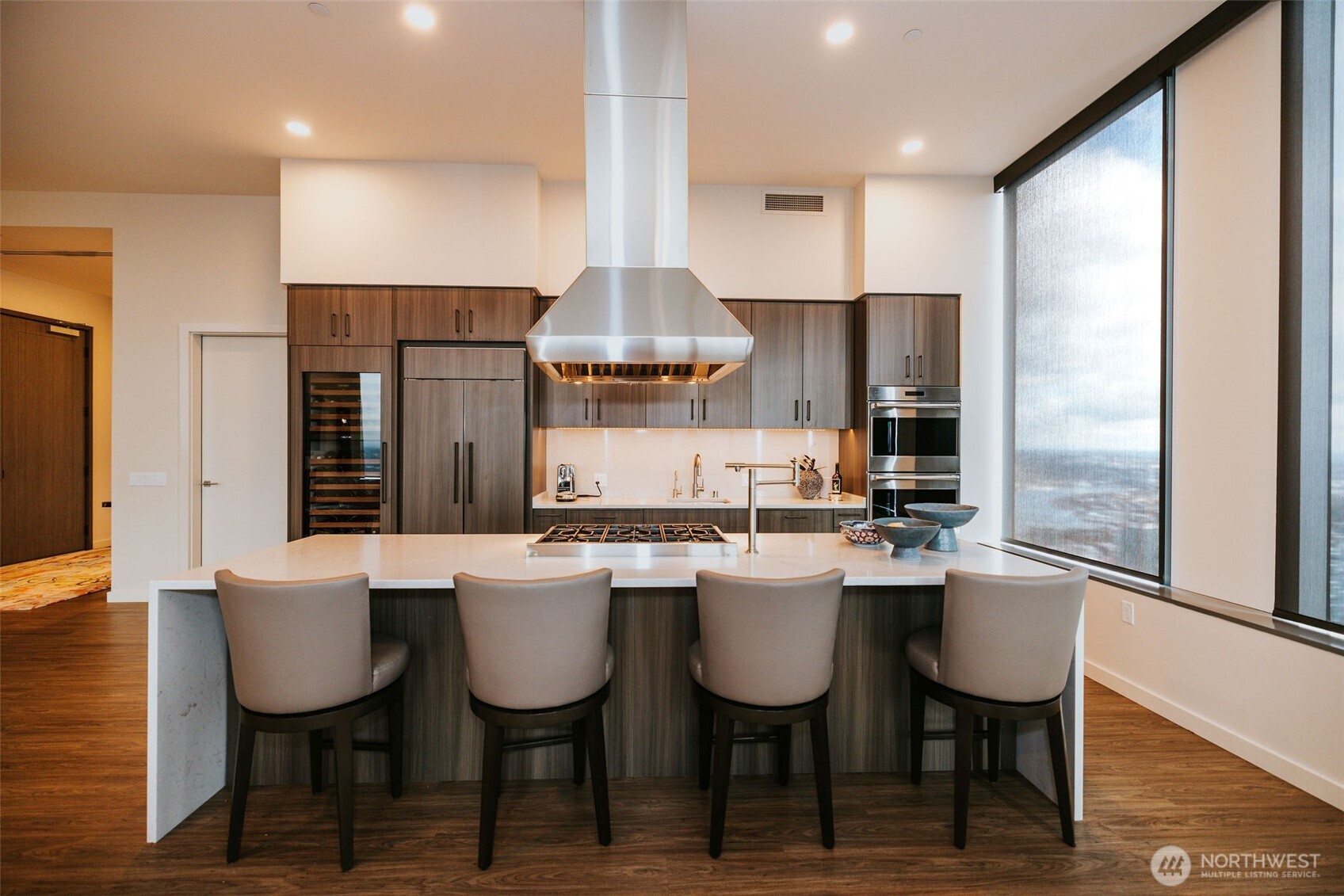 1340 4th Avenue, Unit 5803 Seattle, WA 98101 - Photo 14 of 39 a kitchen with stainless steel appliances a dining table chairs and a refrigerator