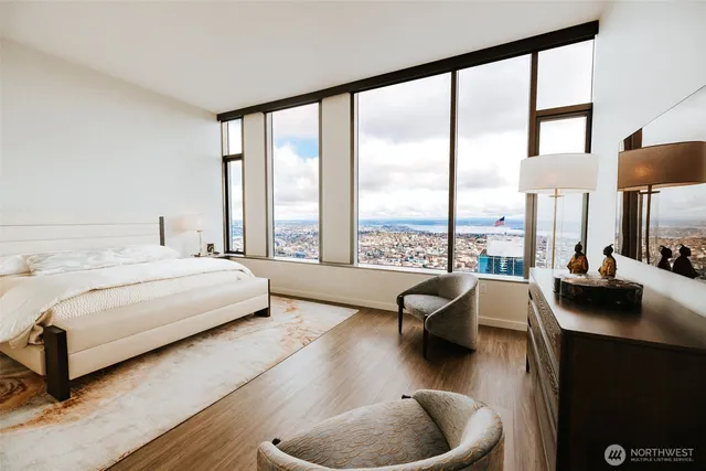 a bedroom with furniture and a large window