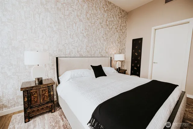 a bedroom with a bed and a tv on a dresser