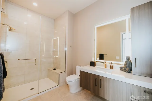 a bathroom with a double vanity sink toilet mirror and shower