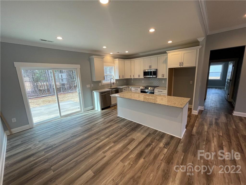 580 Crescent Road Salisbury, NC 28146 - Photo 8 of 38 a large white kitchen with wooden floors and stainless steel appliances