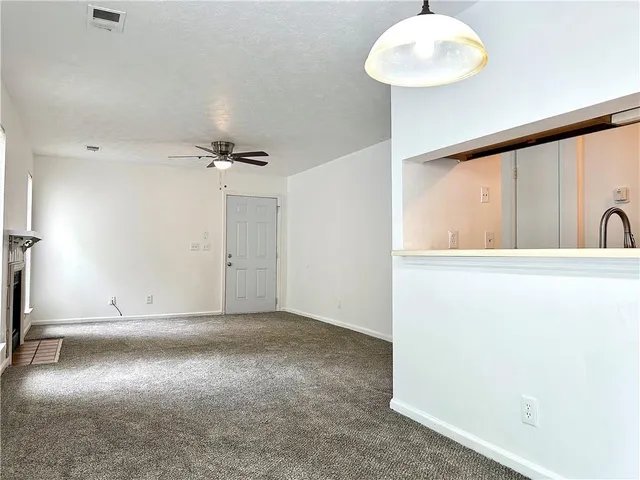 an empty room with windows and fireplace