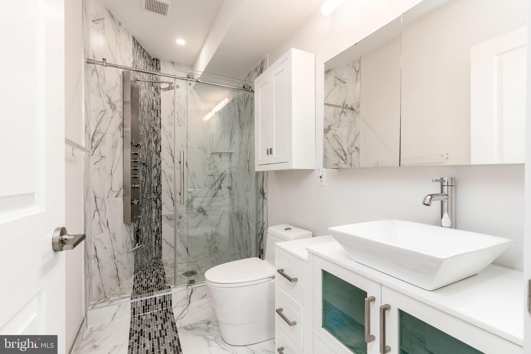 1733 Carpenter Street, Unit D Philadelphia, PA 19146 - Photo 22 of 37 a bathroom with a sink a toilet and shower