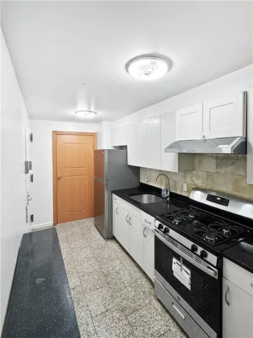 a kitchen with stainless steel appliances granite countertop a stove a sink and a refrigerator