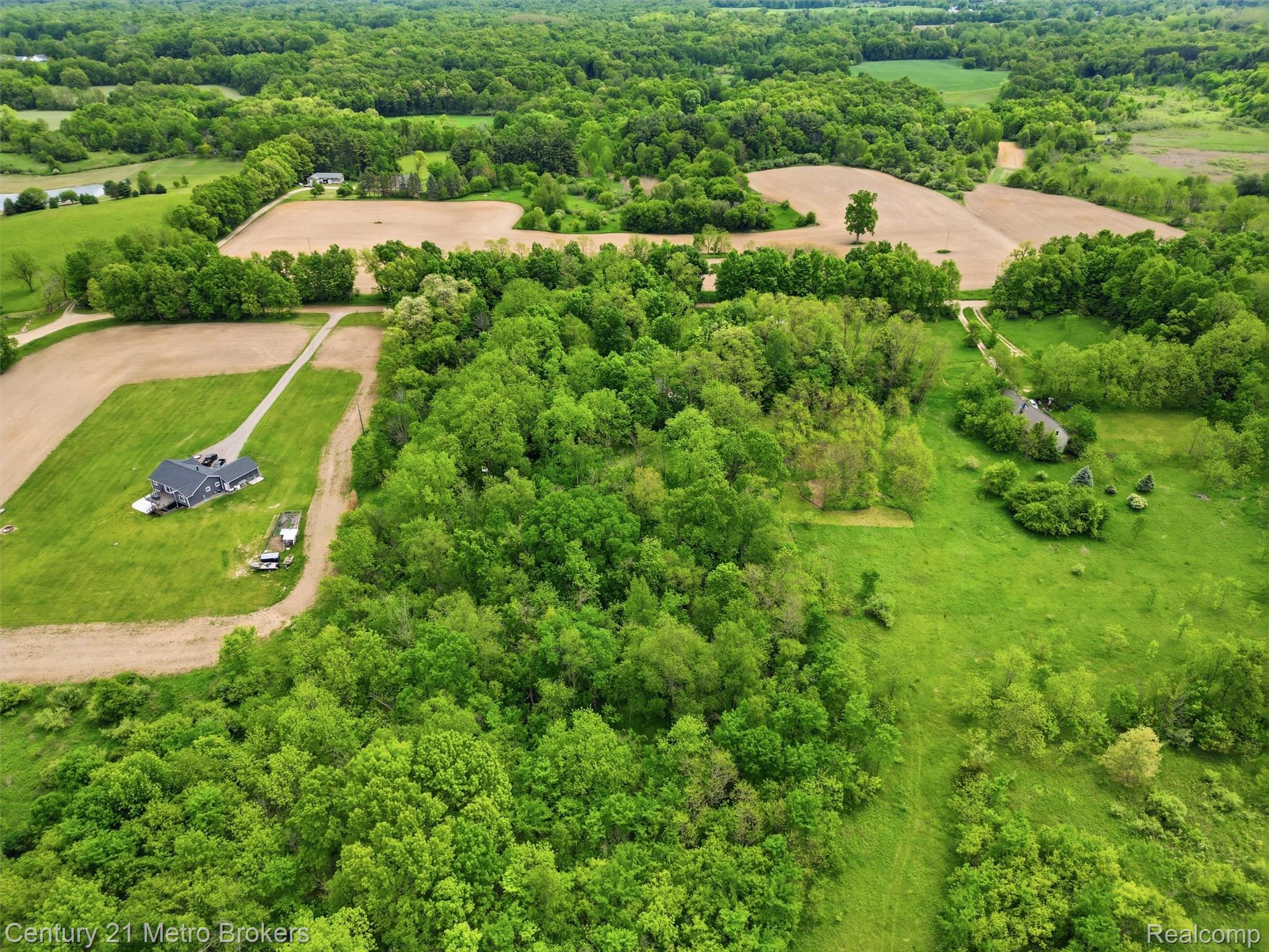 11447 North Latson Road Linden, MI 48451 - Photo 47 of 52 Expansive rural property featuring a modern residence, extensive green spaces, mature tree lines, and cultivated fields