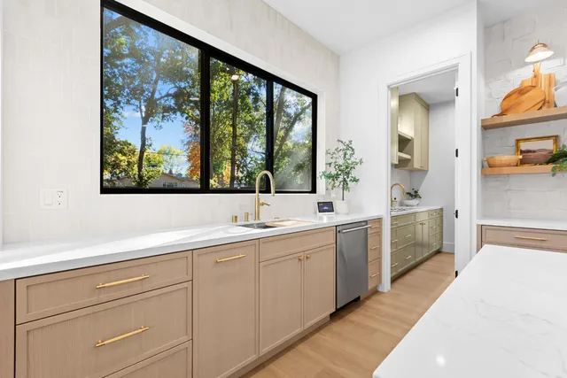 a spacious bedroom with a bed chandelier and a window
