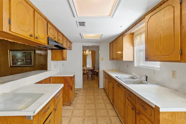 a large kitchen with stainless steel appliances granite countertop a sink and cabinets