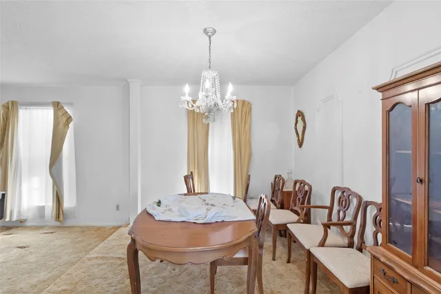 a view of a dining room with furniture and chandelier