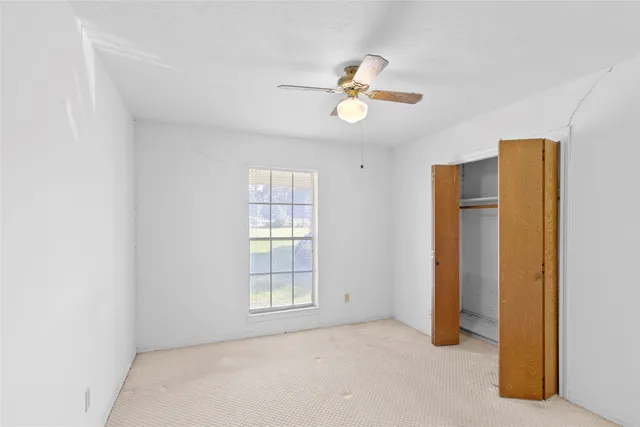 an empty room with windows and closet