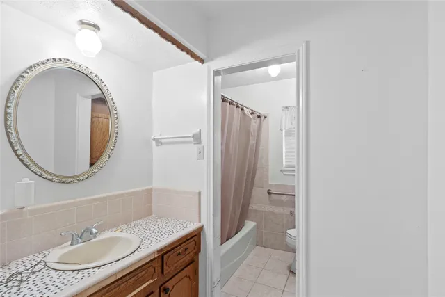 a bathroom with a granite countertop sink toilet and a mirror