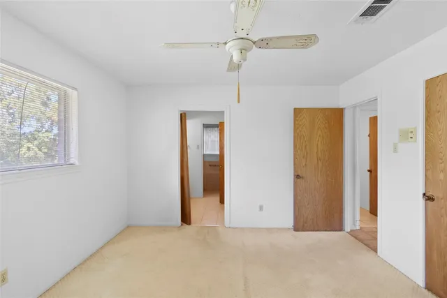 a view of a room with a ceiling fan and a window