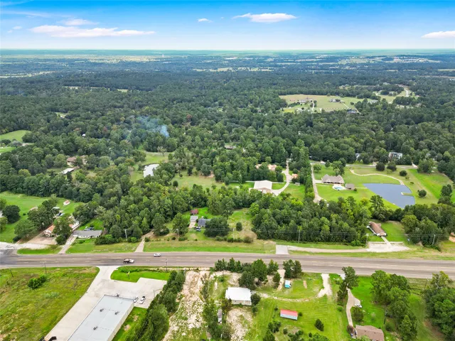 an aerial view of residential houses with outdoor space and trees