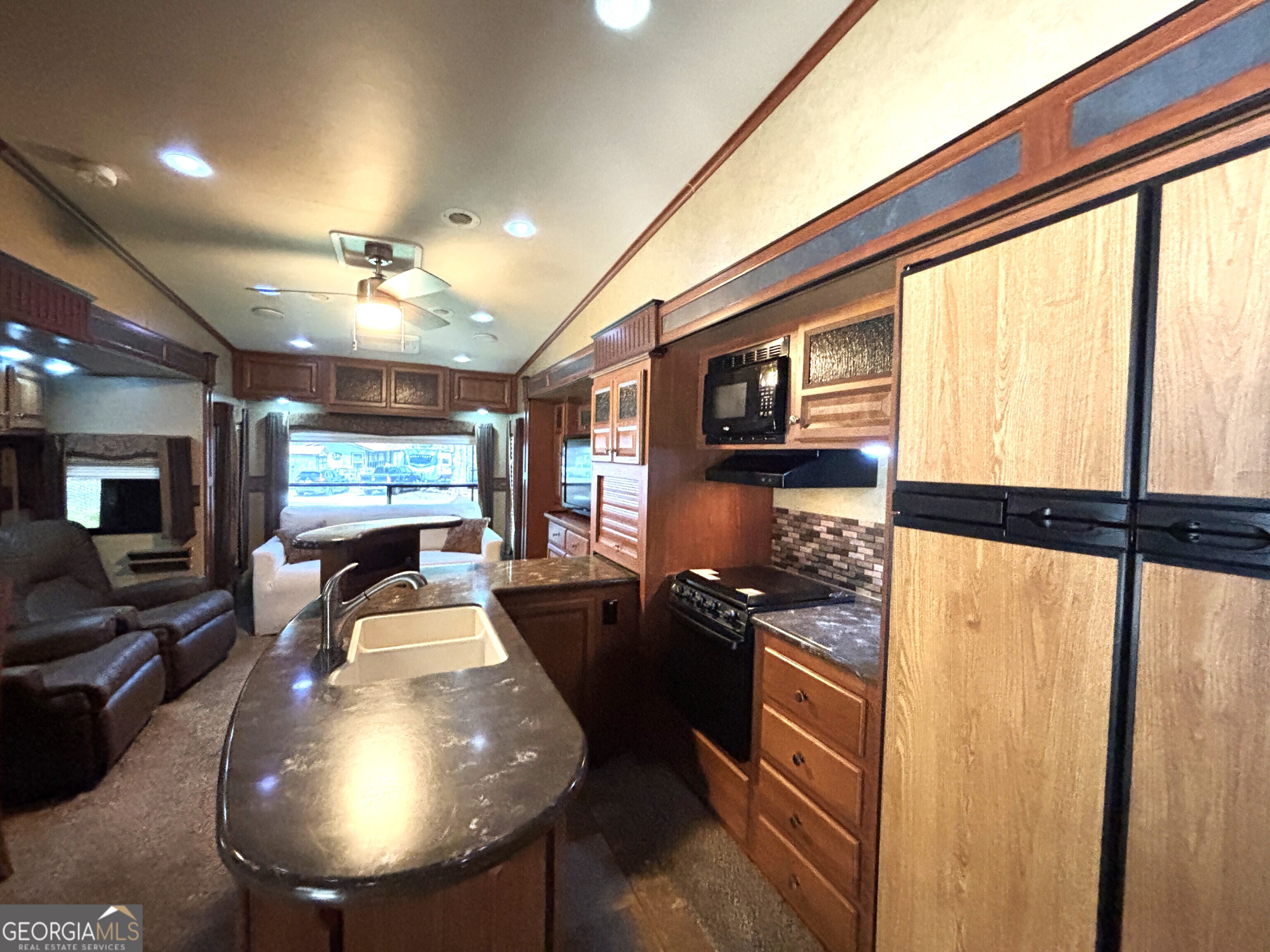 101 Bridge Loop Drive Cleveland, GA 30528 - Photo 19 of 93 a kitchen with stainless steel appliances kitchen island granite countertop a refrigerator a stove and a sink with large windows
