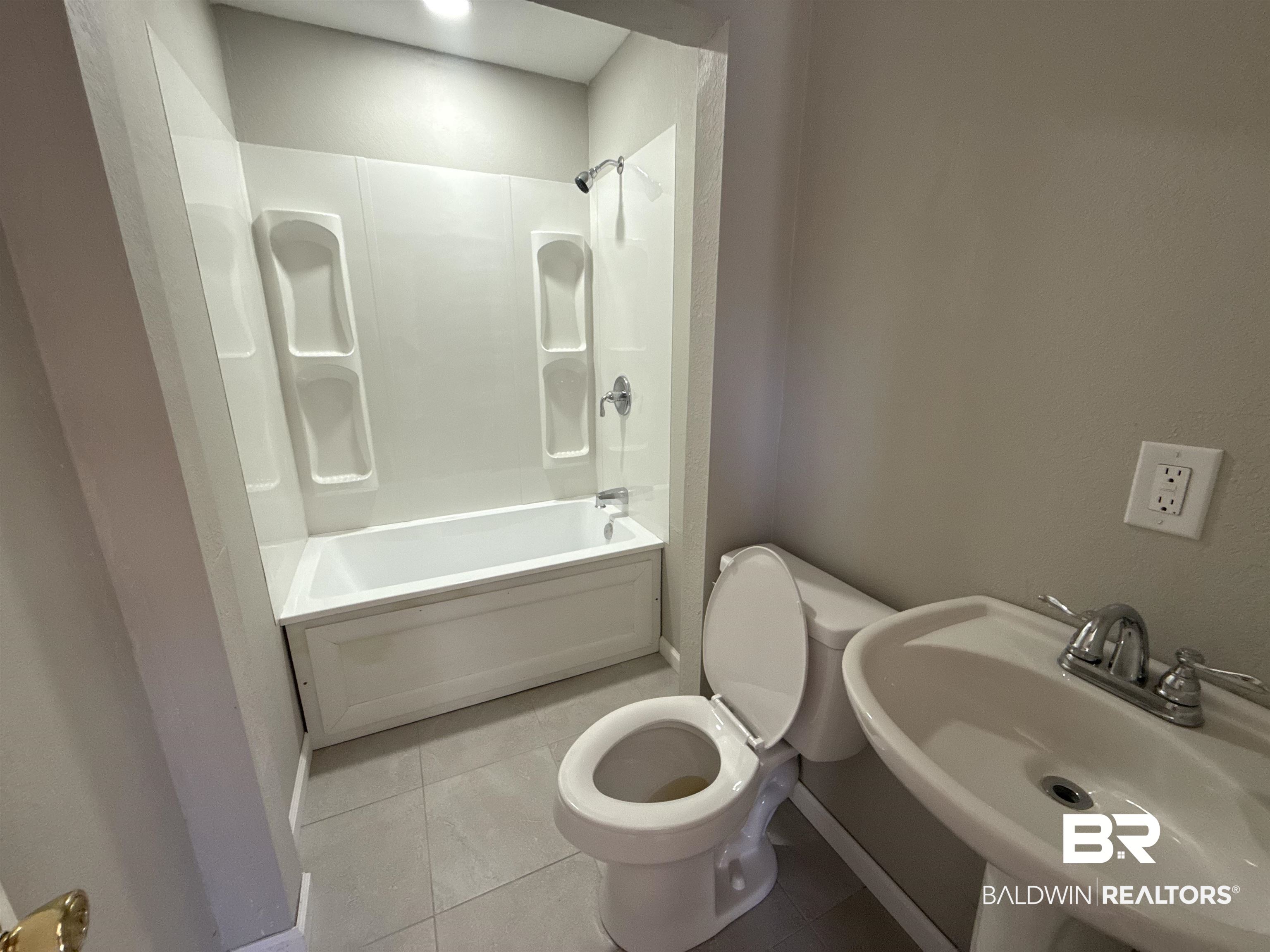 32 Slate Street Atmore, AL 36502 - Photo 13 of 16 Bathroom featuring tile patterned floors and shower / washtub combination