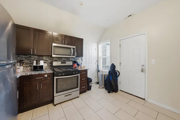 a kitchen with stainless steel appliances a stove a sink and a refrigerator