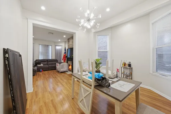a view of a dining room with furniture a chandelier and wooden floor