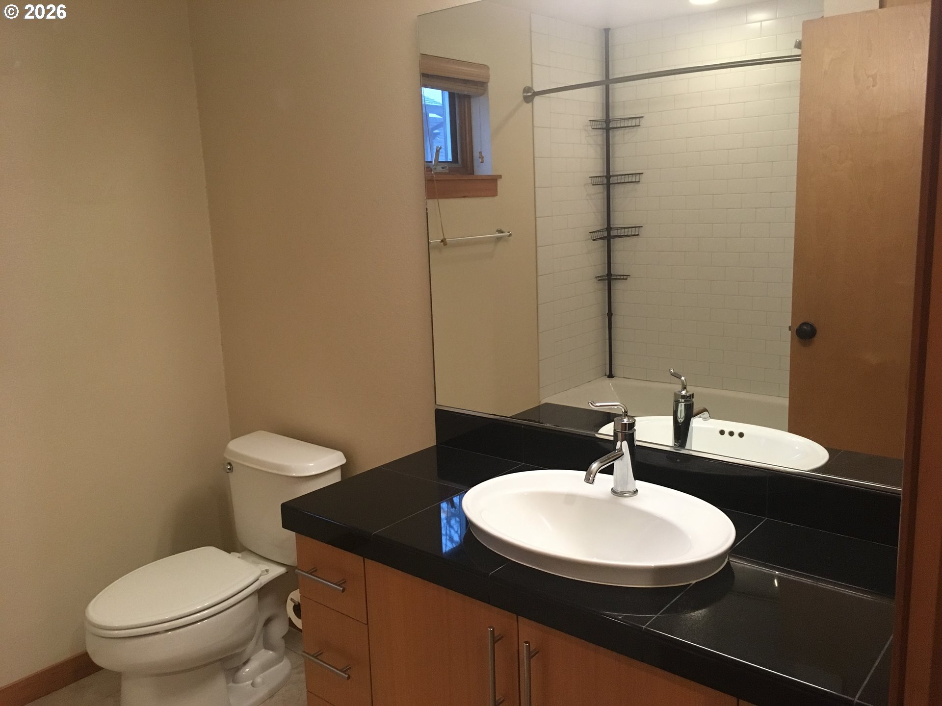7910 Southwest 31st Avenue, Unit 306 Portland, OR 97219 - Photo 13 of 19 a bathroom with a granite countertop sink toilet and a mirror