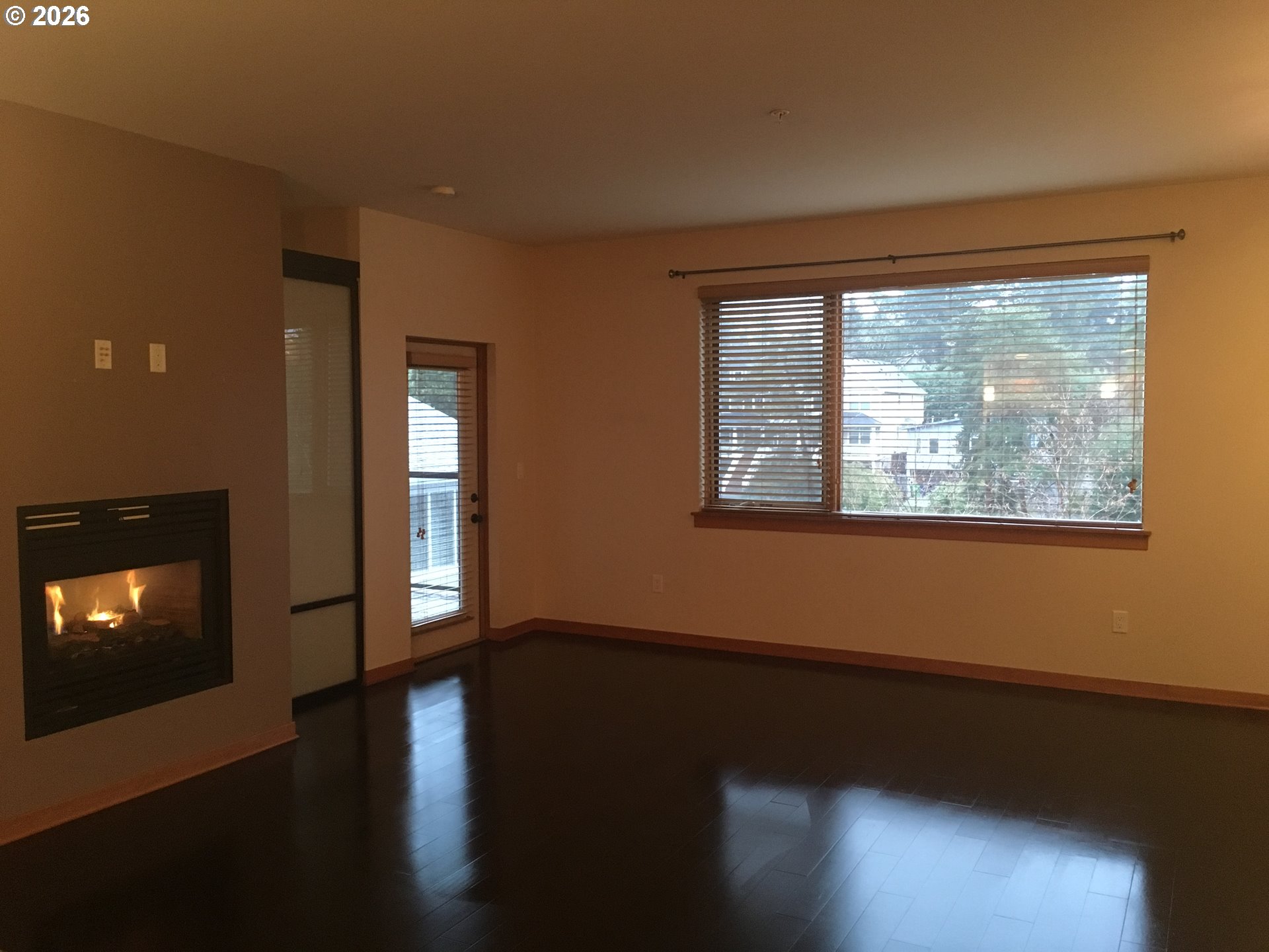 7910 Southwest 31st Avenue, Unit 306 Portland, OR 97219 - Photo 4 of 19 a view of empty room with wooden floor and fireplace