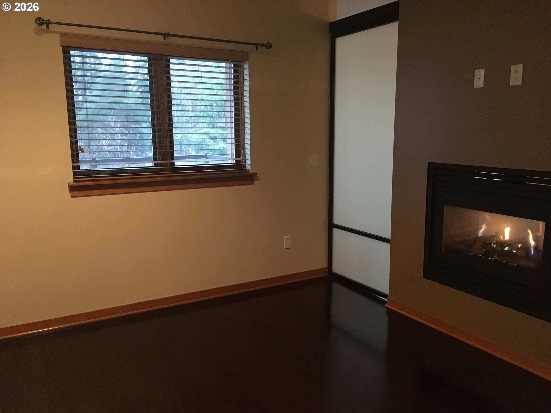 7910 Southwest 31st Avenue, Unit 306 Portland, OR 97219 - Photo 5 of 19 a view of an empty room with wooden floor and a window