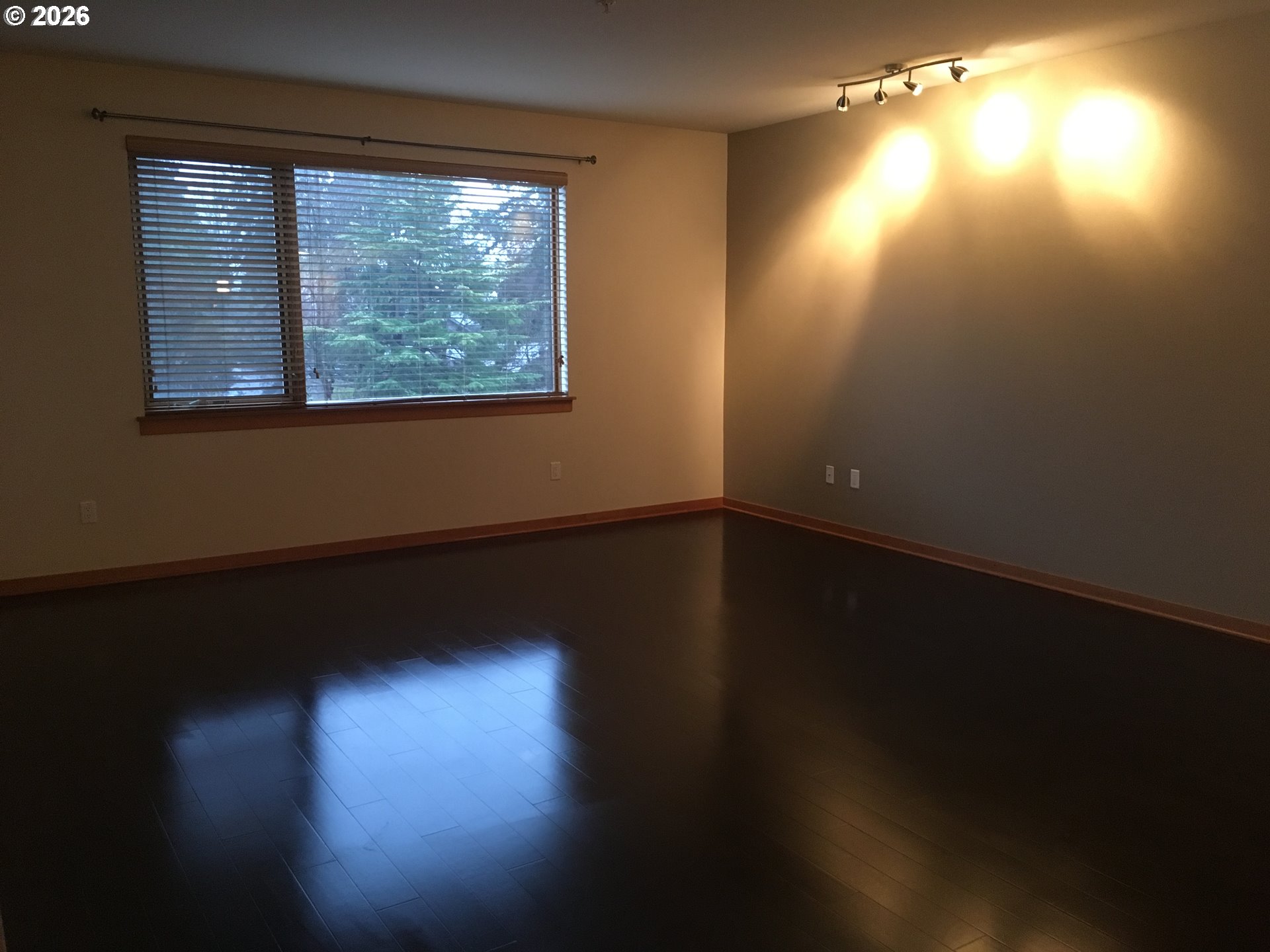 7910 Southwest 31st Avenue, Unit 306 Portland, OR 97219 - Photo 6 of 19 a view of empty room with wooden floor and fan