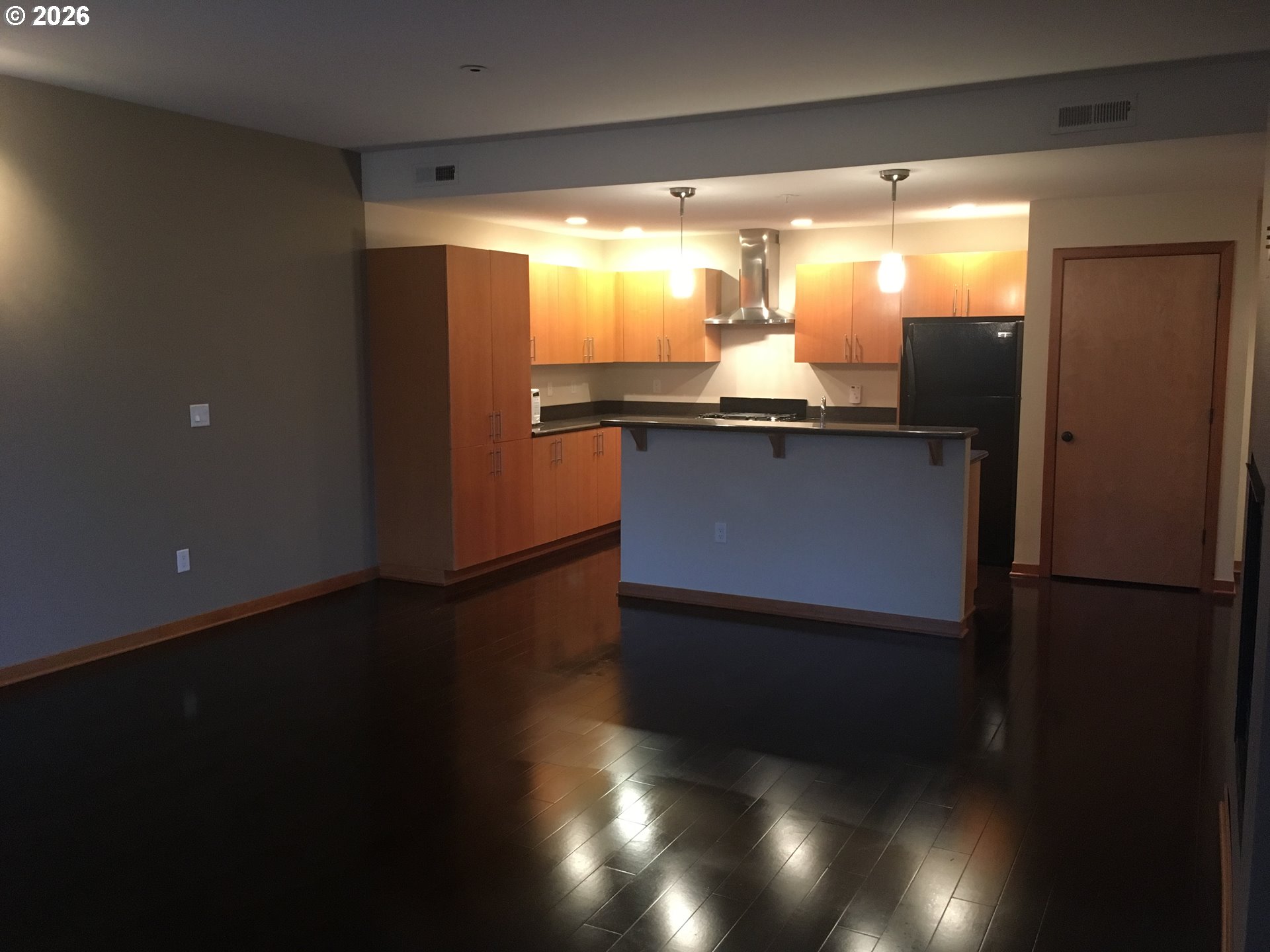 7910 Southwest 31st Avenue, Unit 306 Portland, OR 97219 - Photo 8 of 19 a kitchen with granite countertop white cabinets and wooden floor