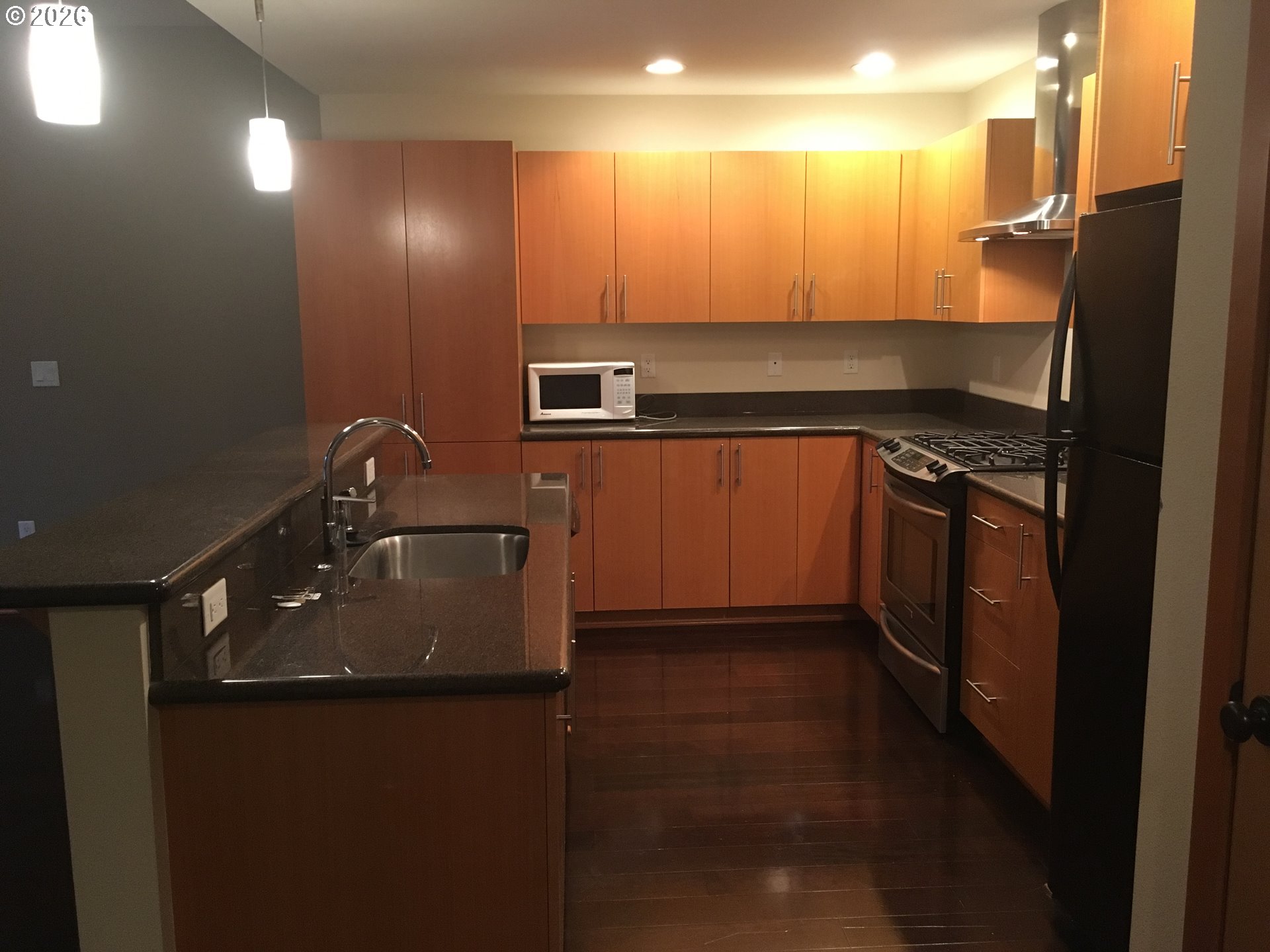7910 Southwest 31st Avenue, Unit 306 Portland, OR 97219 - Photo 9 of 19 a kitchen with stainless steel appliances a sink stove and refrigerator