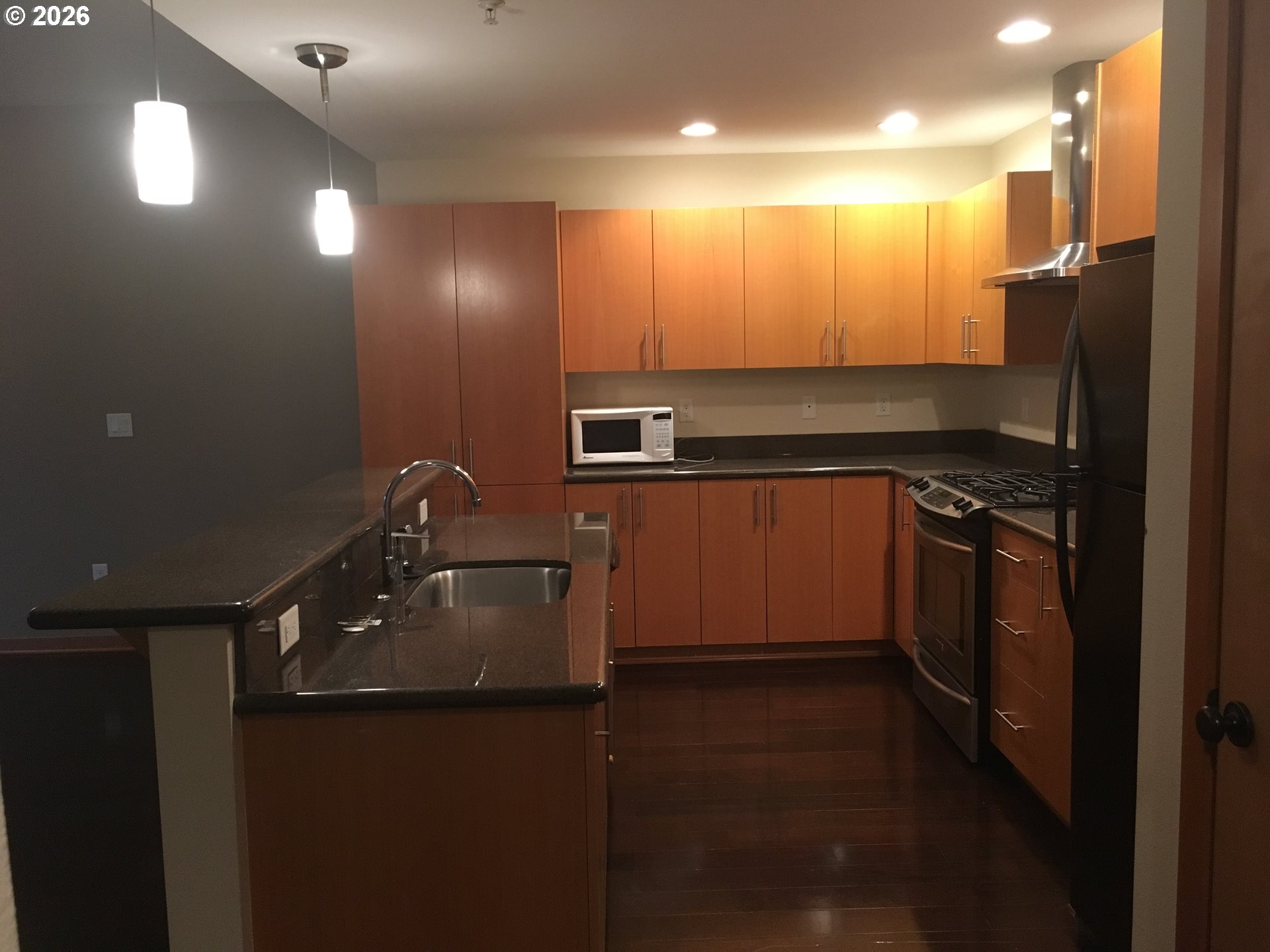 7910 Southwest 31st Avenue, Unit 306 Portland, OR 97219 - Photo 10 of 19 a kitchen with kitchen island a sink stainless steel appliances and cabinets