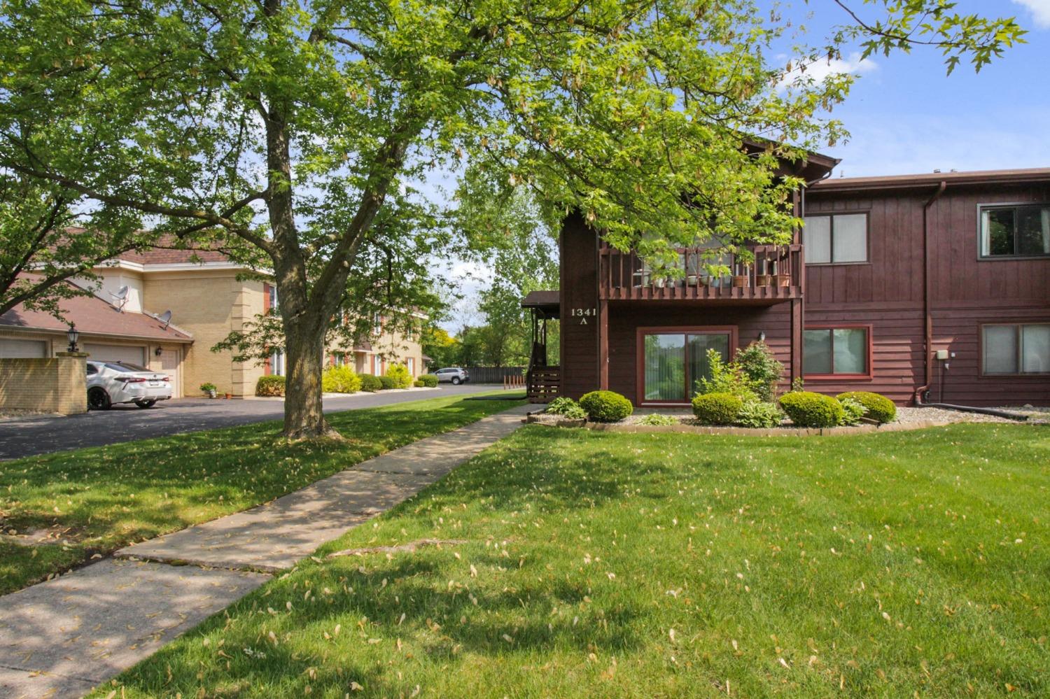 a view of a house with backyard and a tree