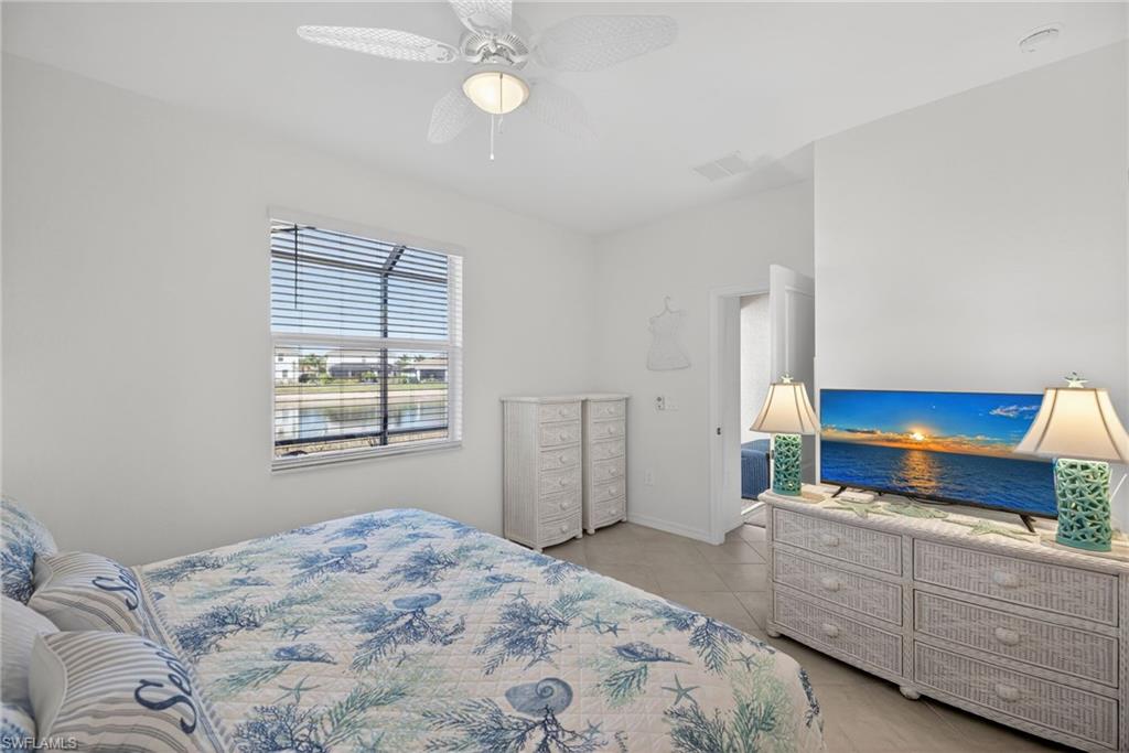 2323 Dragonfruit Way Naples, FL 34120 - Photo 14 of 32 a bedroom with a bed and a dresser next to a window