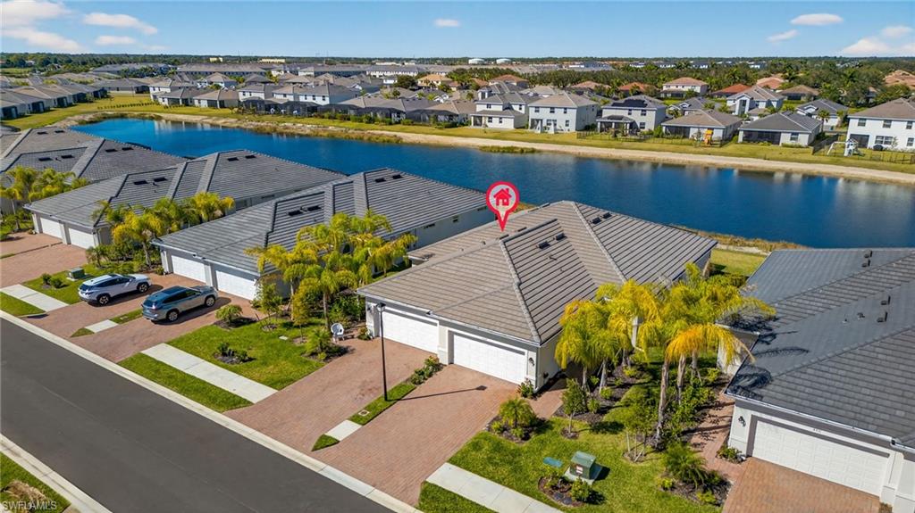 2323 Dragonfruit Way Naples, FL 34120 - Photo 24 of 32 an aerial view of a house with a swimming pool tennis courts and ocean view