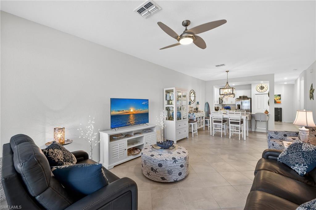 2323 Dragonfruit Way Naples, FL 34120 - Photo 4 of 32 a living room with furniture a fireplace and a flat screen tv