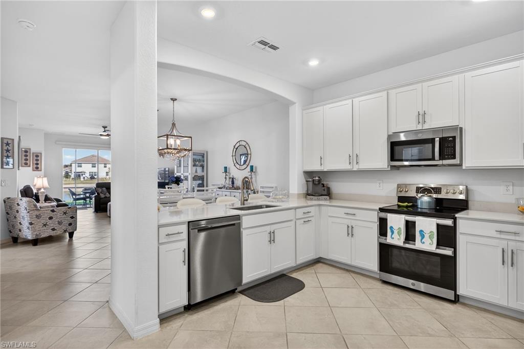 2323 Dragonfruit Way Naples, FL 34120 - Photo 7 of 32 a kitchen with a sink and white cabinets