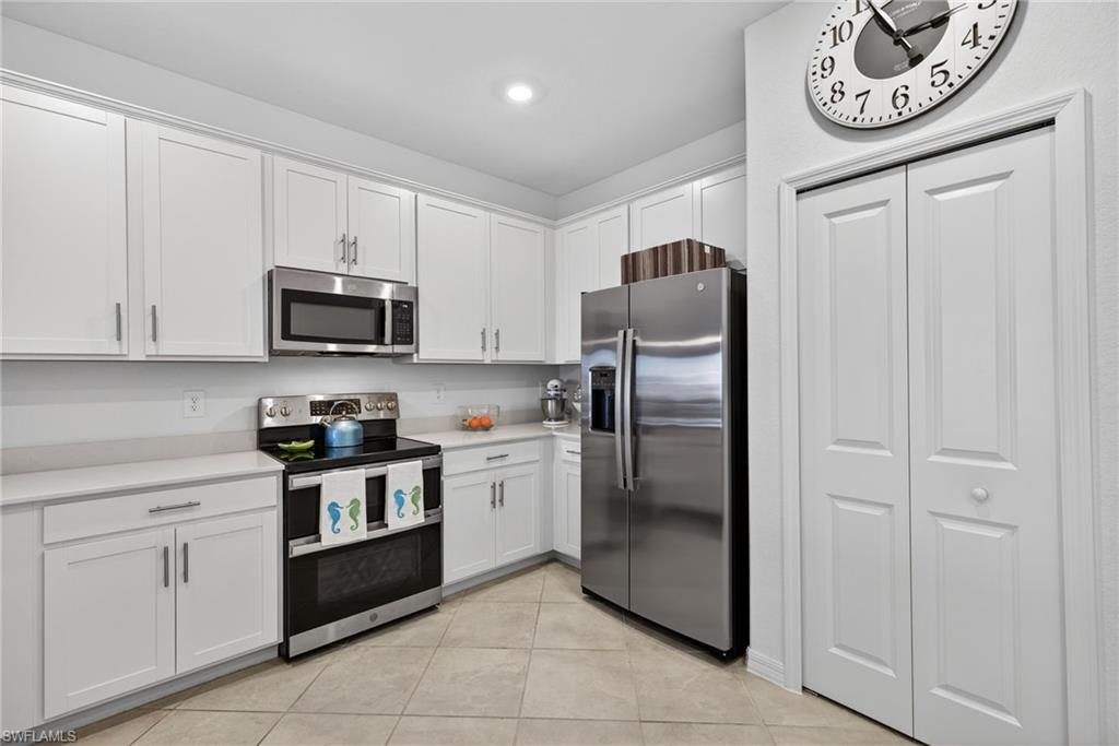 2323 Dragonfruit Way Naples, FL 34120 - Photo 9 of 32 a kitchen with stainless steel appliances granite countertop a refrigerator and a stove top oven