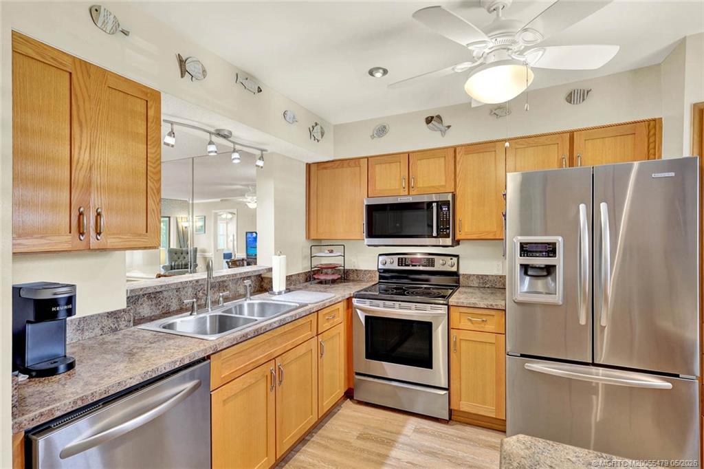 1950 Southwest Palm City Road, Unit 2102 Stuart, FL 34994 - Photo 13 of 55 a kitchen with stainless steel appliances granite countertop a sink a stove a refrigerator cabinets and wooden floor