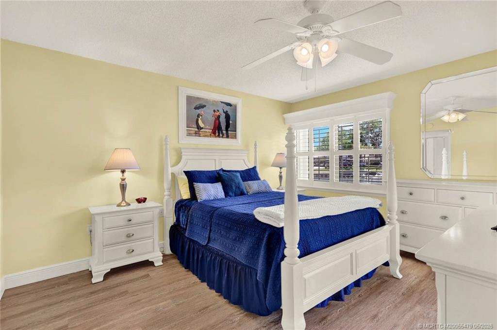 1950 Southwest Palm City Road, Unit 2102 Stuart, FL 34994 - Photo 25 of 55 a bedroom with a bed and a chandelier