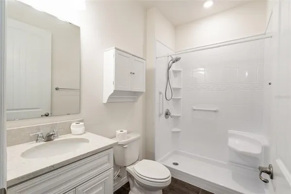 a bathroom with a sink toilet vanity and shower