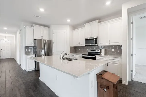 a kitchen with refrigerator cabinets and wooden floor
