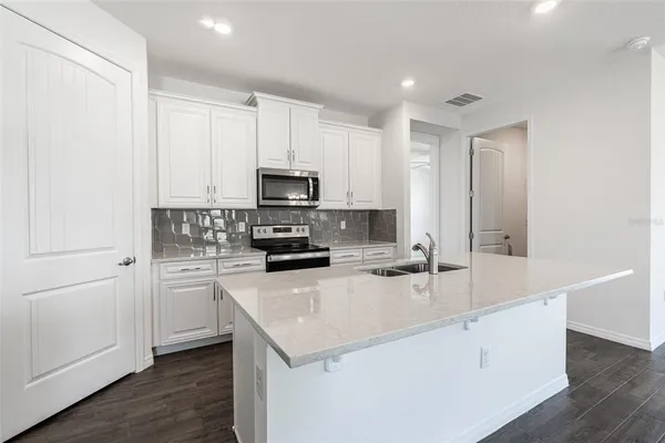 a kitchen with appliances a sink and cabinets